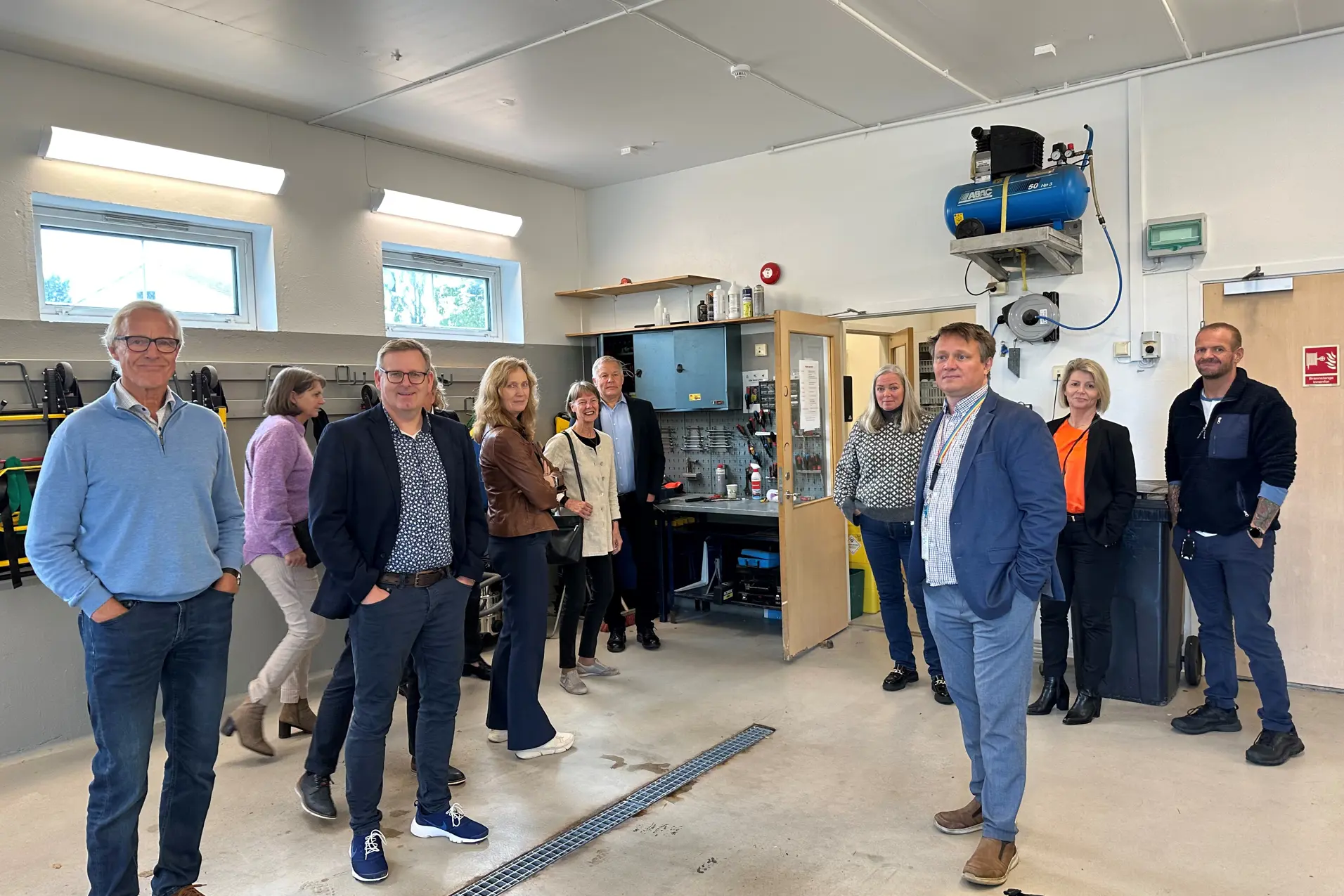 En gruppe mennesker som står i et rom med en stor maskin