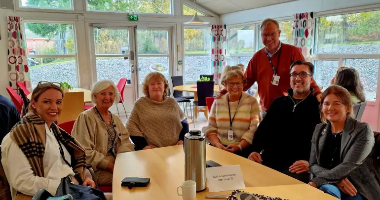En gruppe mennesker som sitter ved et bord