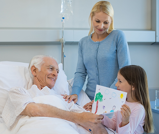 A woman standing next to a man in a hospital bed