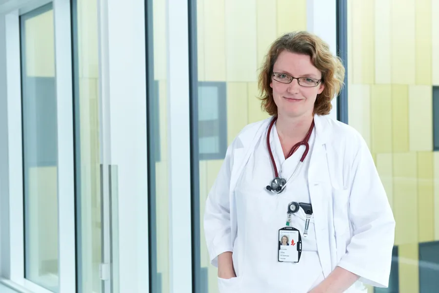 En person iført hvit frakk og stetoskop