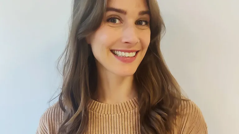 En kvinne som smiler til kameraet