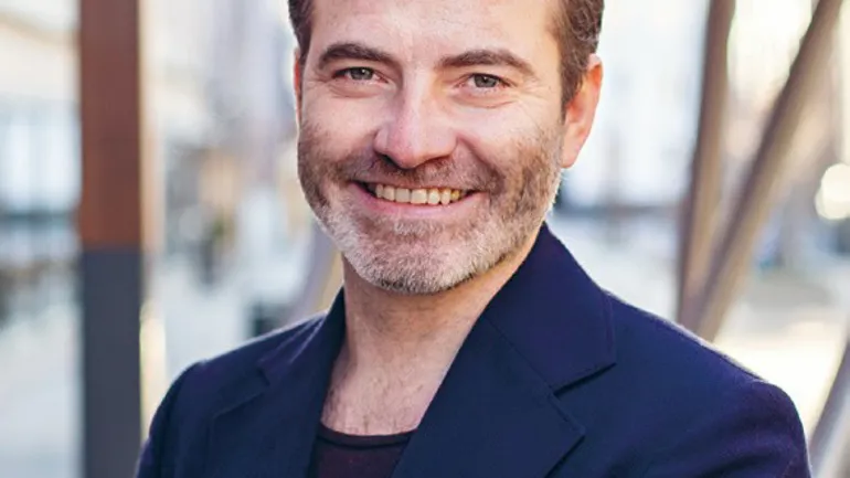 En mann som smiler til kameraet