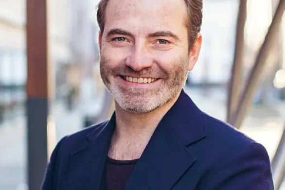 En mann som smiler til kameraet