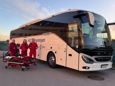 Helseekspressbuss med tre medarbeidere stående foran