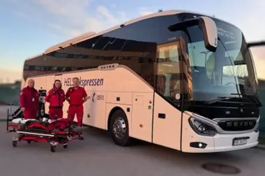 Helseekspressbuss med tre medarbeidere stående foran