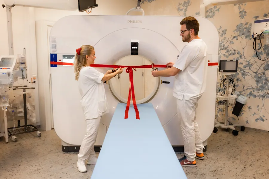 En mann og en kvinne i et rom med en stor hvit maskin