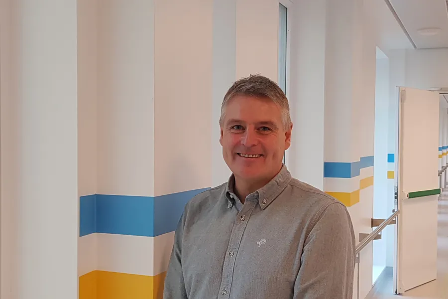 En mann som smiler til kameraet